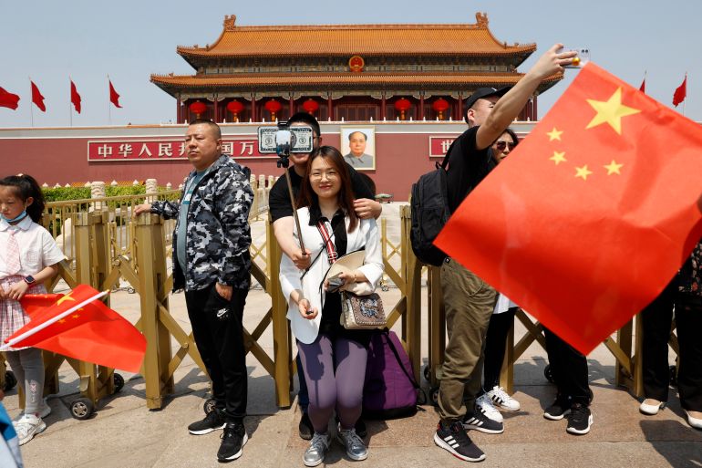 Visitors pose for photos in front of Tiananmen Gate