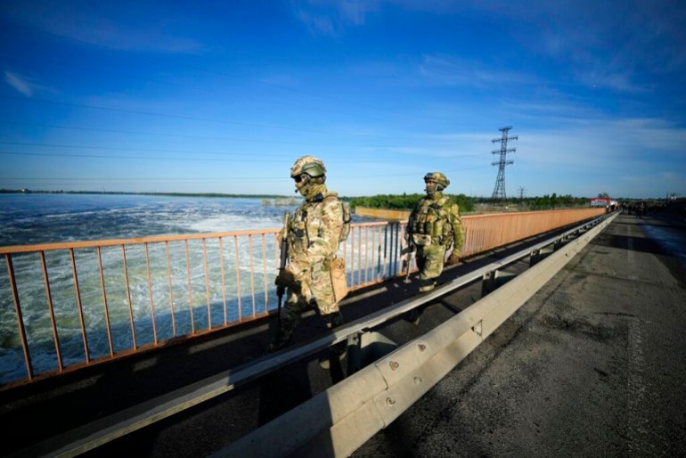 FILE - Russian troops patrol an area at the Kakhovka Hydroelectric Station, a run-of-river power plant on the Dnieper River in Kherson region, south Ukraine, on May 20, 2022. Moscow has warned that Ukraine may try to attack the dam at the Kakhovka hydroelectric power plant about 50 kilometers (30 miles) upstream and flood broad areas, including the city of Kherson. Ukrainian forces pressing an offensive in the south have zeroed in on Kherson, a provincial capital that has been under Russian control since the early days of the invasion. This photo was taken during a trip organized by the Russian Ministry of Defense. (AP Photo, File)