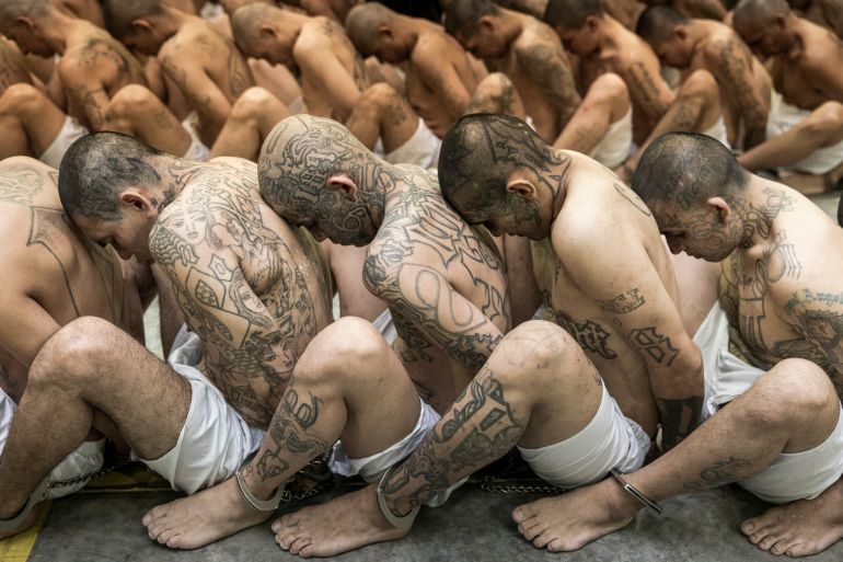 In this photo provided by El Salvador's presidential press office, inmates identified by authorities as gang members are seated on the prison floor of the Terrorism Confinement Center in Tecoluca, El Salvador, Wednesday, March 15, 2023