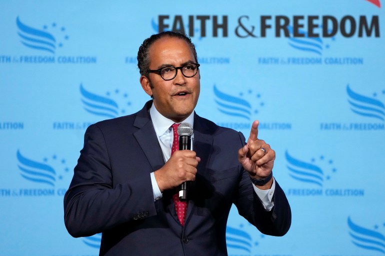 Will Hurd speaks into a microphone in front of a banner that reads "Faith & Freedom".