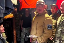Wagner Group's Yevgeny Prigozhin in a video grab. He's visiting a camp with Wagner soldiers.He's wearing a khaki-coloured baseball hat and jacket.