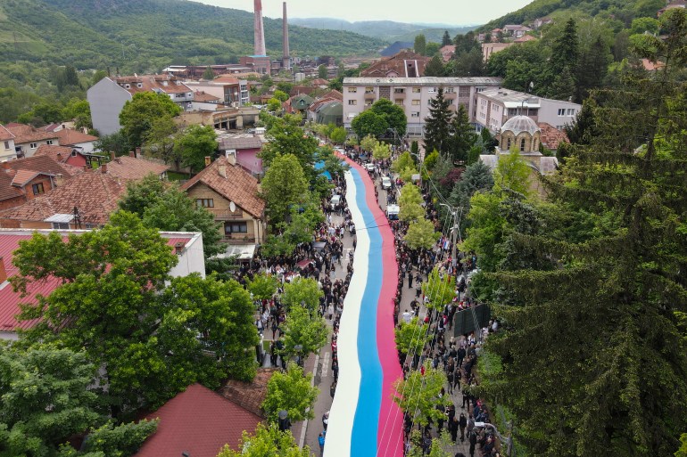 People hold a giant Serbian flag during a protest in the town of Zvecan, northern Kosovo