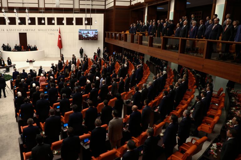 Newly elected legislators stand in parliament