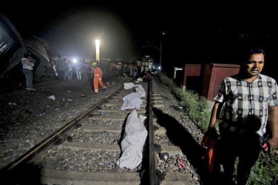 Bodies recovered from passenger trains lay on the track at the site of an accident in Balasore district