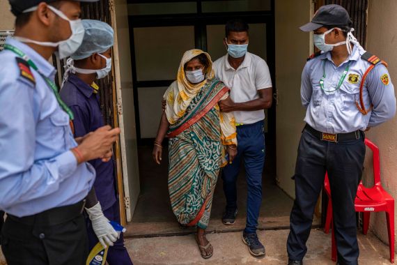 Jenima Mondal, center, whose son Mamjur Ali Mondal died in Friday's train accident is helped by a health worker after she identified the body at the All India Institute of Medical Sciences hospital in Bhubaneswar