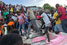 People carry an injured person from a home that collapsed after the earthquake in Jeremie, Haiti. [Ralph Simon/AP Photo]