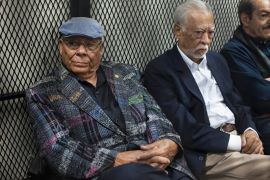 Former army officer Benedicto Lucas Garcia, left, sits in a cell in a courtroom in Guatemala City in 2017 [File: Moises Castillo/AP]