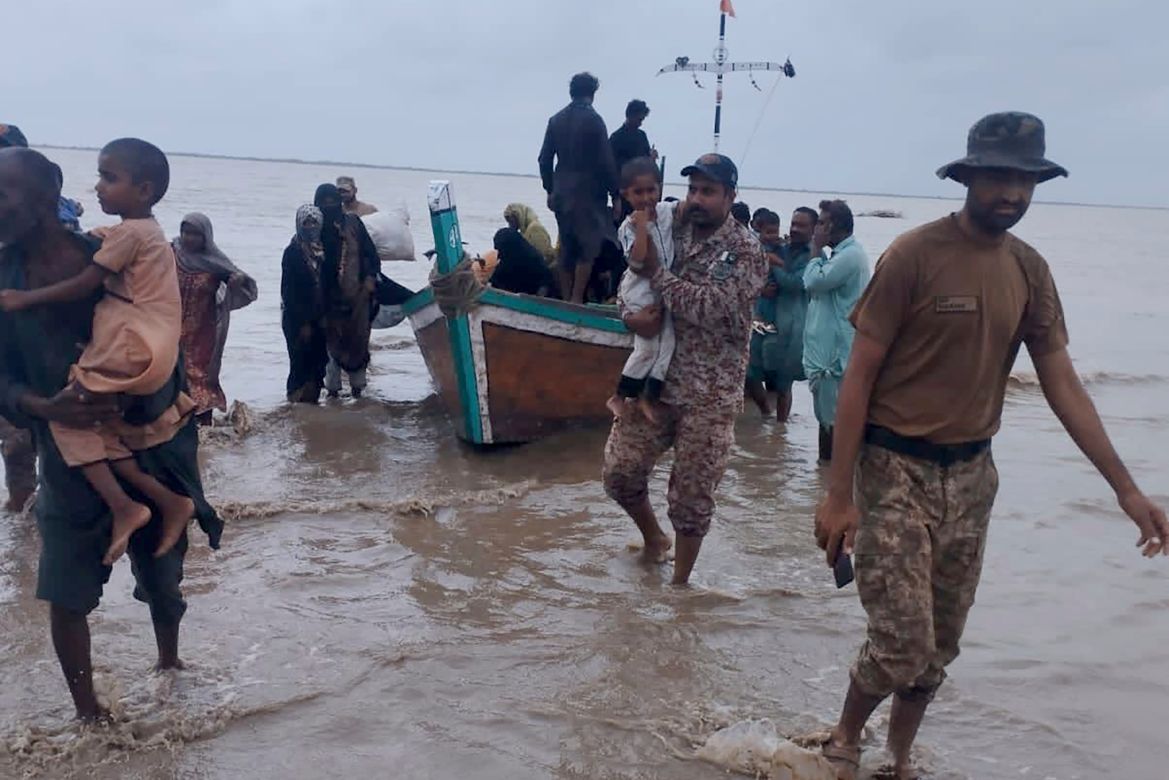 In this picture released by Pakistan's Sindh Rangers, paramilitary soldiers help to evacuate people from a village