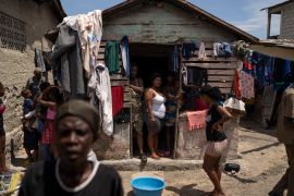 People displaced by gang violence stand in a makeshift encampment in Port-au-Prince, Haiti