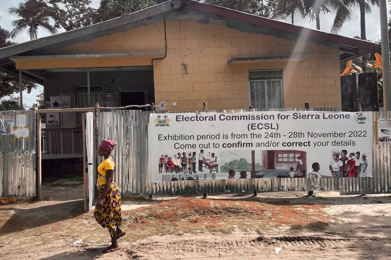 A woman walks past a polling station in Freetown, Sierra Leone