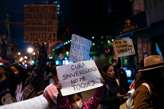 People hold up signs in a protest in Bolivia
