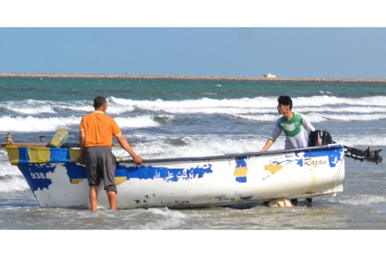 Dua pria meluncurkan perahu ke laut