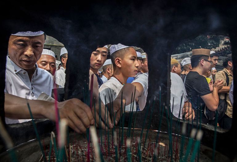 Chinese Hui Muslim men light incense at the "Sheiks Tombs" after Eid prayers at the historic Niujie Mosque in Beijing, China 