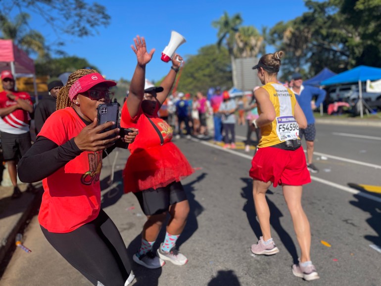 Members of Ashleigh Adams' running club, Run Alex, cheering for Comrades participants near the race's 70 kilometer mark in Pinetown, a suburb of Durban, South Africa.