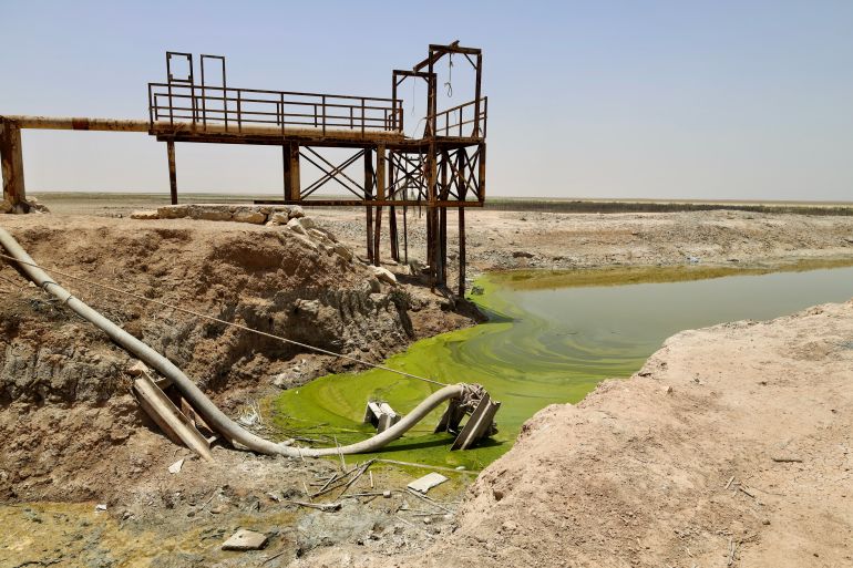 The closest water to Al Ankour, lime green and polluted from flow of water to the lake. A former pipe used to transport water from Habbaniyah Lake to the village sits discarded in the sludge.