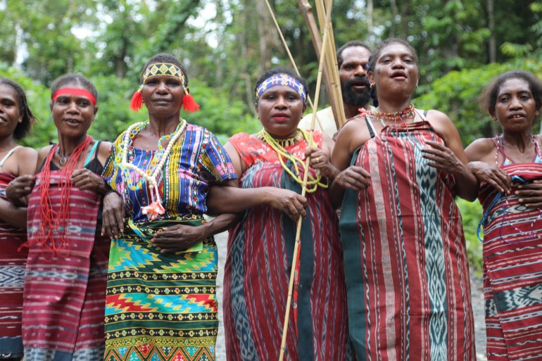 Three Ogoney women standing in the forest