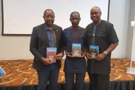Haggak in the middle flanked by Nigeria sports minister Sunday Dare (L) and publisher Enefiok Udo-Obong (R)