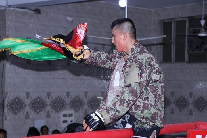 Hashime dengan bendera Afghanistan selama pertarungan internasional (Sayed Waris Hashime)