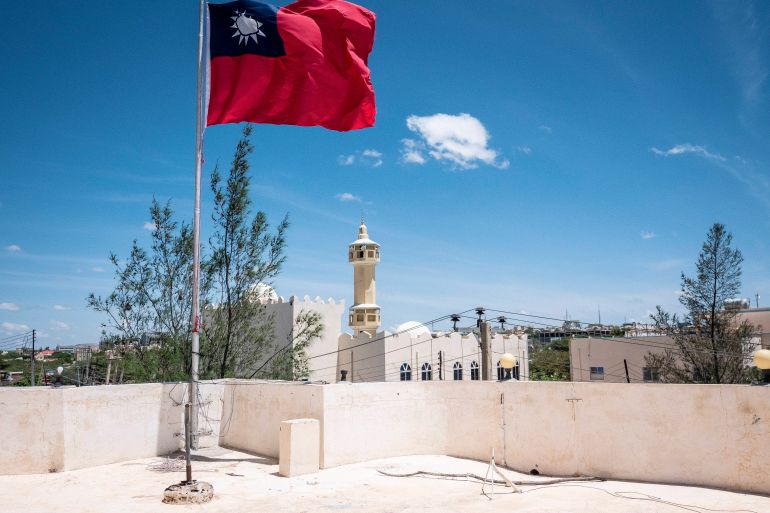 A Taiwanese flag flying in Somaliland. There is white mosque behind and the sky is blue