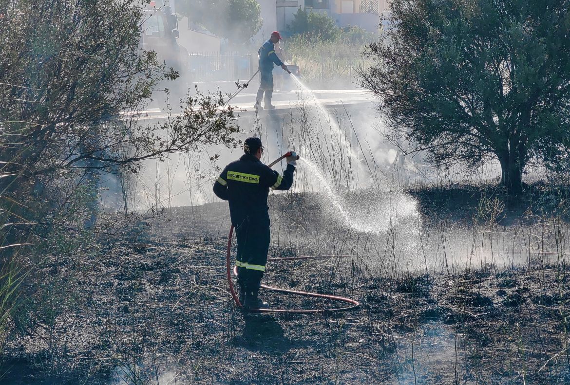Firefighters work to contain a wildfire in the coastal city of Nafplio, Peloponnese region, Greece