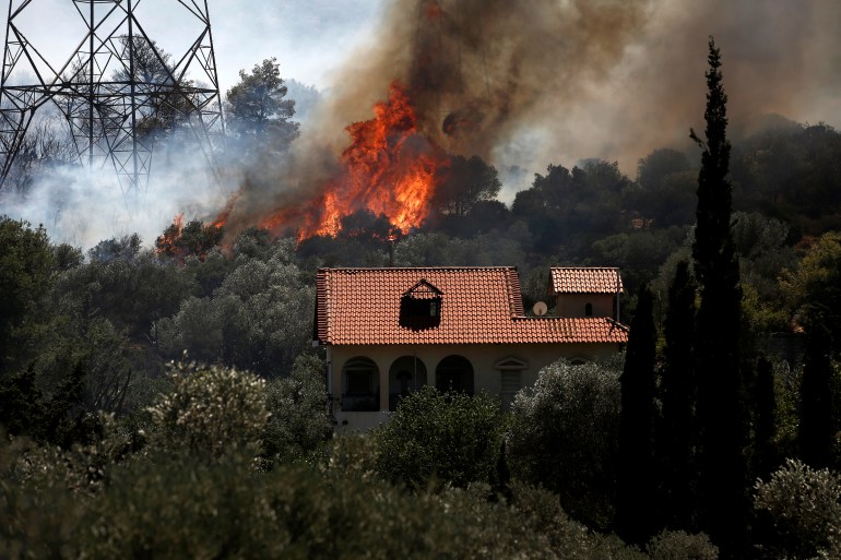 epa10751574 A fire burns next to high voltage electricity pylons at Kouvaras area in Attica, Greece, 17 July 2023. Firefighting forces are battling a blaze that broke out in the Kouvaras area in Attica, while a warning was sent via the emergency number 112 to evacuate several settlements in southeast Attica. A force of 55 firefighters and 20 fire engines, two units on foot and 31 Romanian firefighters with five water tankers have been deployed to put out the fire, assisted by six fire-fighting aircraft and four helicopters from the air. EPA-EFE/YANNIS KOLESIDIS