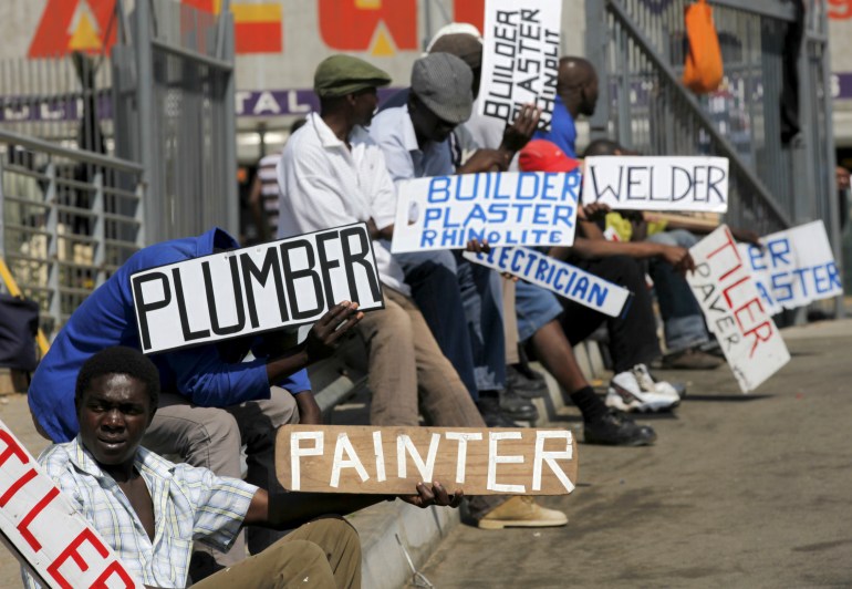 People hold placards asking for jobs in south Africa
