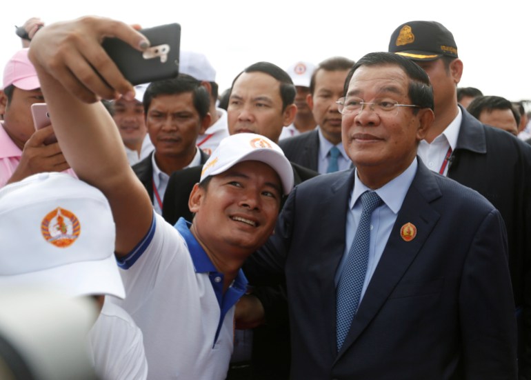 Seorang pendukung berswafoto dengan Perdana Menteri Kamboja Hun Sen, yang juga presiden Partai Rakyat Kamboja (CPP) yang berkuasa, setelah upacara untuk memperingati 66 tahun berdirinya partai tersebut, di Pulau Koh Pich Phnom Penh, Kamboja, 28 Juni 2017 .REUTERS/Samrang Pring