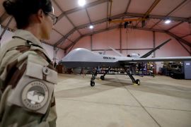 A French soldier of the regional anti-insurgent Operation Barkhane stands in front of a General Atomics MQ-9 Reaper drone version Block 1 in Niamey