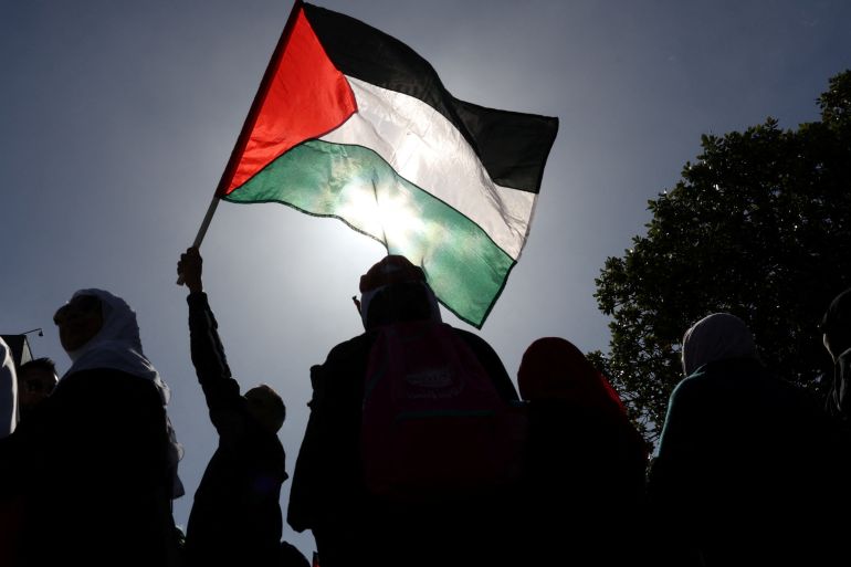 A person hold a Palestinian flag during the annual al-Quds day (Jerusalem Day), during the month of Ramadan in Cape Town, South Africa, April 14, 2023. REUTERS/Esa Alexander