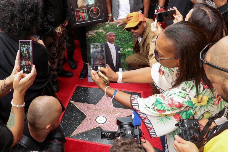 People take pictures of rapper Tupac Shakur's star during his posthumous induction ceremony on the Hollywood Walk of Fame on June 7, 2023 in Los Angeles, California, US.  REUTERS/Mario Anzuoni