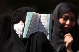 An Iranian protester holds the Quran in her hand during a protest