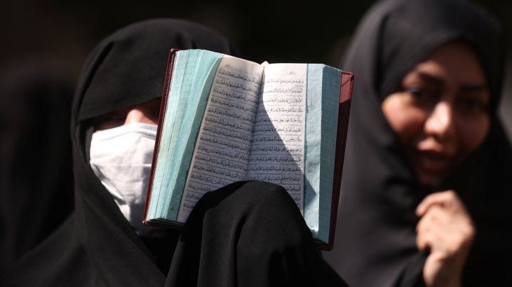 An Iranian protester holds the Quran in her hand during a protest