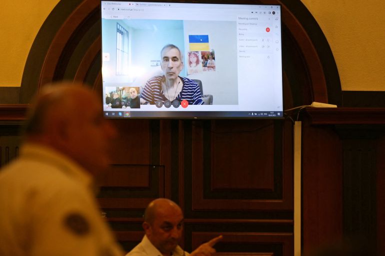Georgia's jailed ex-President Mikheil Saakashvili appears on a screen via a video link from a clinic during a court hearing in the case of the violent dispersal of anti-government mass protests in 2007, in Tbilisi, Georgia July 3, 2023. REUTERS/Irakli Gedenidze