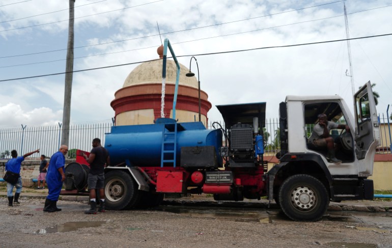 سائق يملأ خزان شاحنة لنقل المياه في هافانا ، كوبا ، 