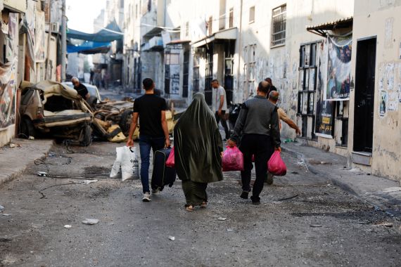 People carry their belongings on the street after the Israeli army's withdrawal from the Jenin camp, in Jenin, in the Israeli-occupied West Bank July 5, 2023. REUTERS/Ammar Awad