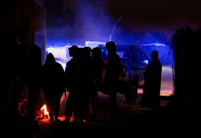 People silhouetted in the dark at the Angelo settlement, near Boksburg