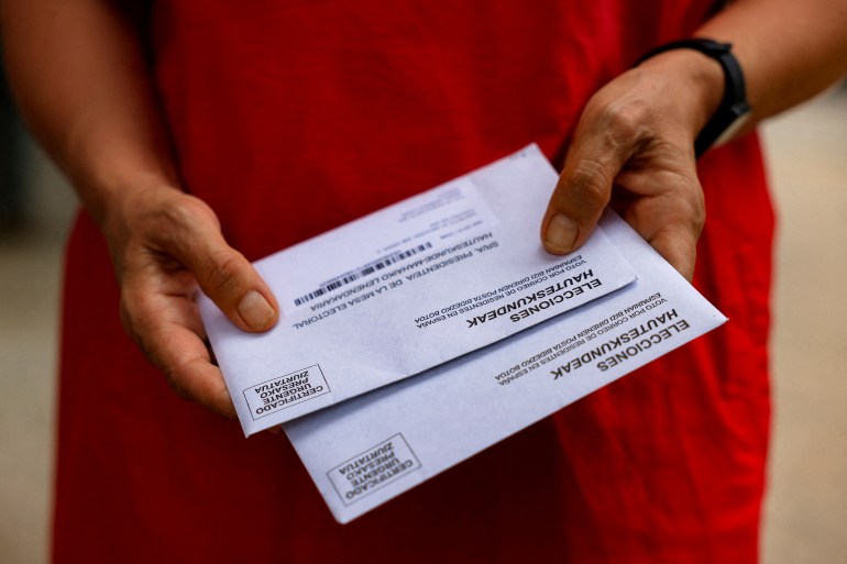 A woman prepares her postal vote ahead of the July 13 deadline for postal voting in Spain's snap general elections