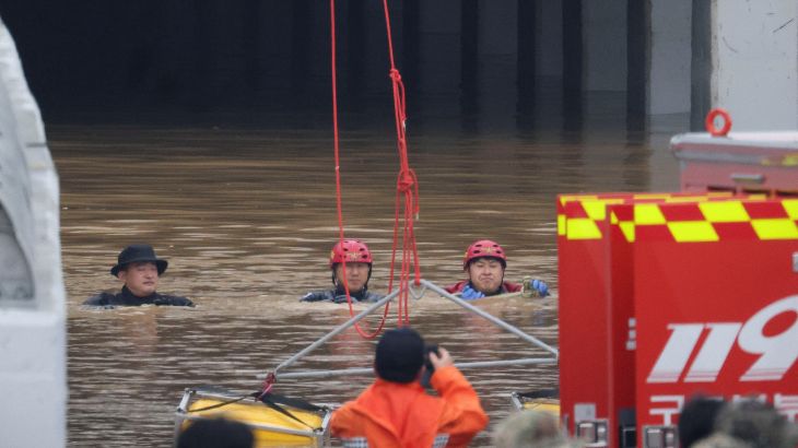 Rescue workers take part in a search and rescue operation near a submerged underpass
