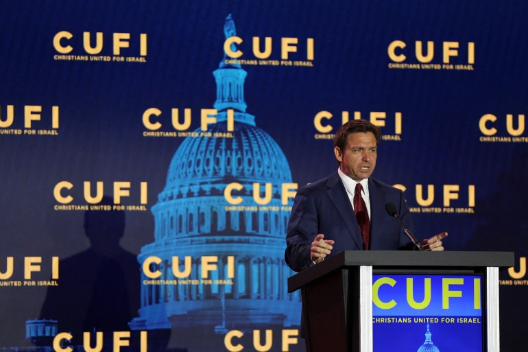 Ron DeSantis atrás de um pódio, em frente a uma tela que mostra o Capitólio e a sigla CUFI