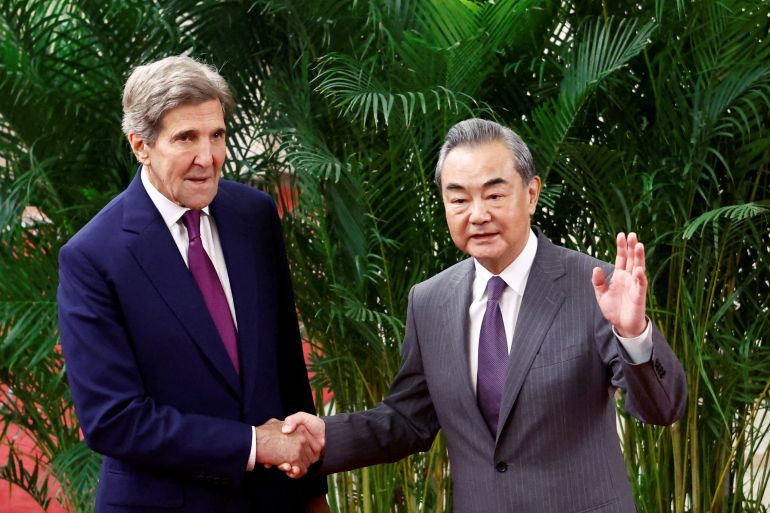 U.S. Special Presidential Envoy for Climate John Kerry and Chinese top diplomat Wang Yi shake hands before a meeting at the Great Hall of the People in Beijing