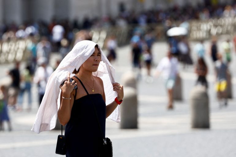 A woman walks during a heatwave across Italy