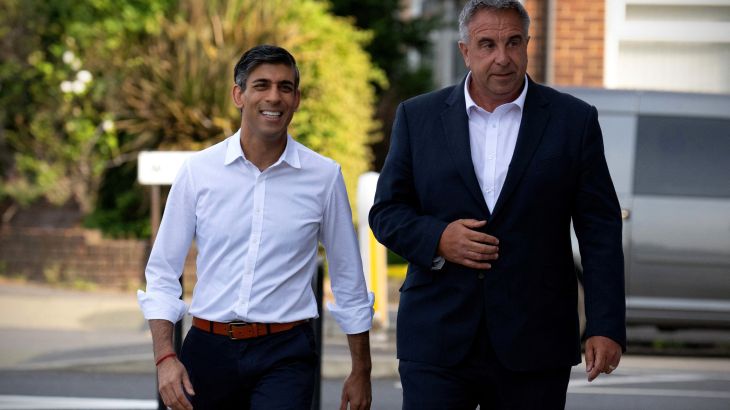 Britain's Prime Minister, Rishi Sunak (L), walks with the new Conservative Party MP for Uxbridge and South Ruislip, Steve Tuckwell, following his win in the local by-election
