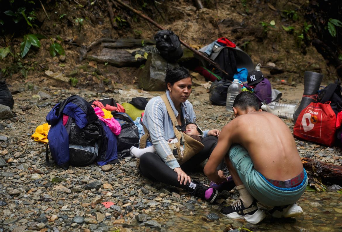 A Venezuelan migrant is helped by a fellow migrant