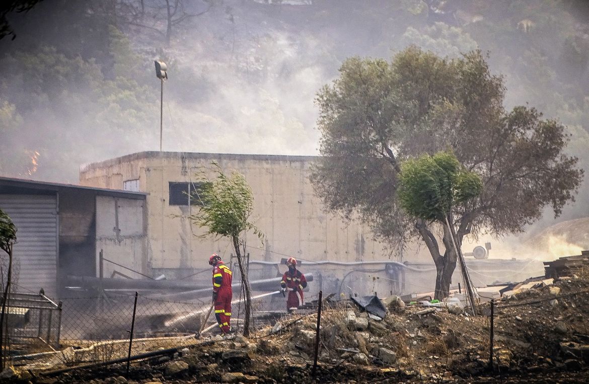 Firefighters operate near a wildfire on the island of Rhodes,