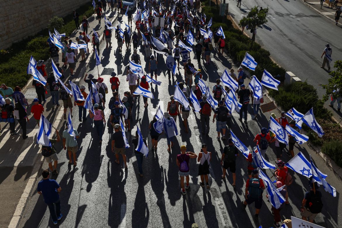 Protesters hold Israeli flags during a demonstration against Israeli Prime Minister Benjamin Netanyahu