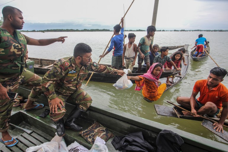 Soldiers provide food aid to the affected families in flooded residential areas following heavy monsoon rainfalls in Goyainghat on June 23, 2022