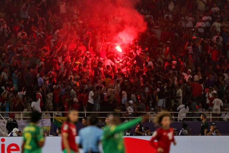 Suporter Maroko menyalakan obor di tribun 