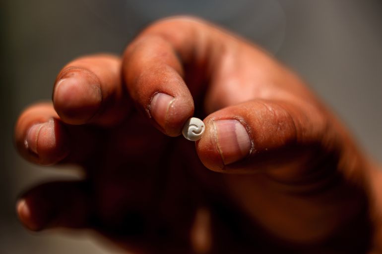 A Lebanese security official holds a single confiscated captagon pill in his hand at the judicial police headquarters in the city of Zahle in Lebanon's central Bekaa valley.