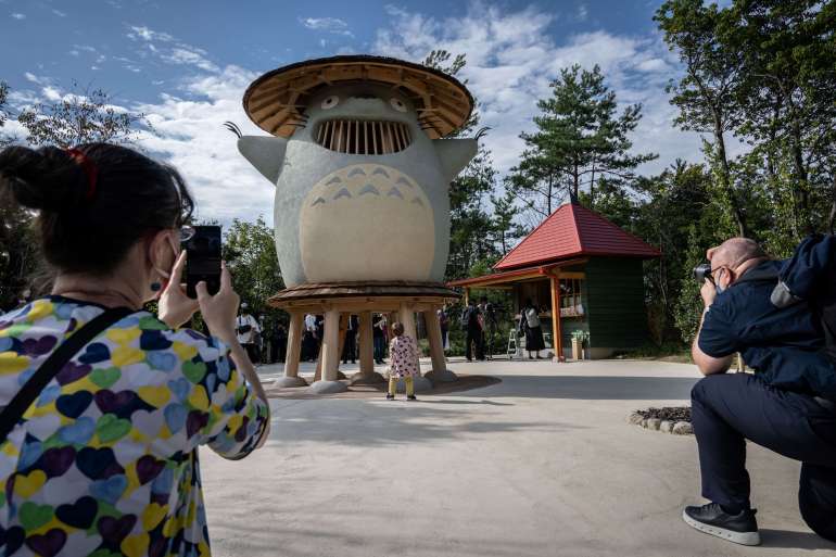 アニメスタジオの映画を基にした新しい遊園地でジブリのキャラクターの写真を撮る人々