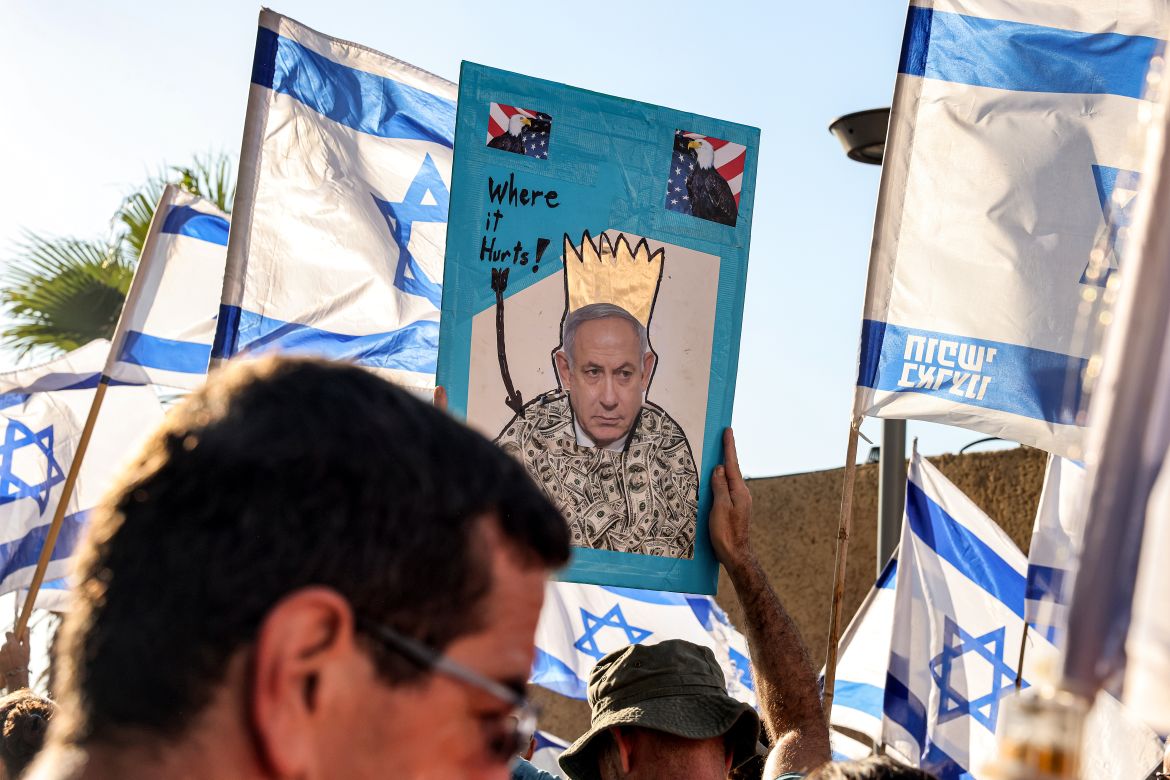 A demonstrator holds up a sign showing the face of Israel's Prime Minister